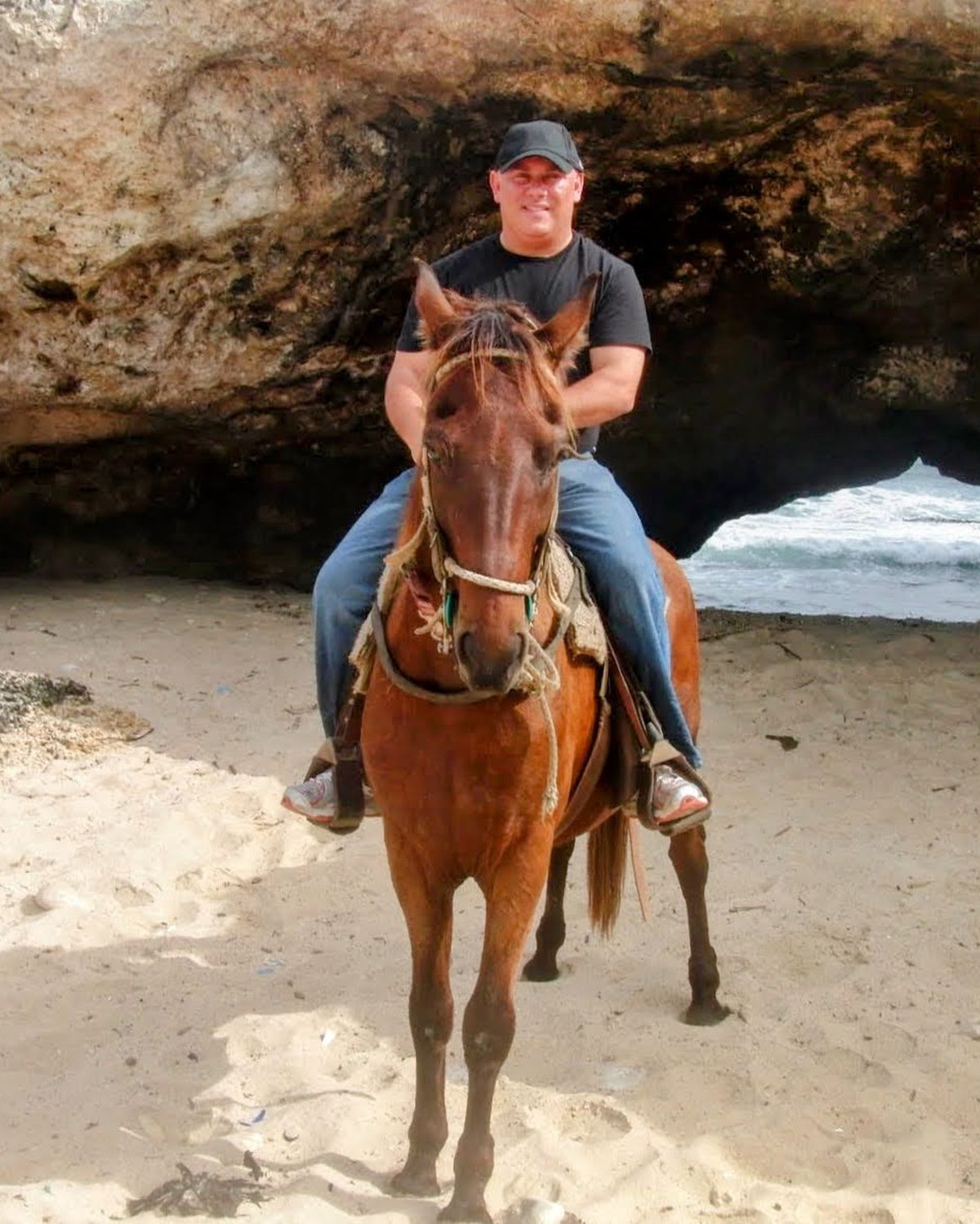 David Alan Graham riding a horse on a beach in Aruba